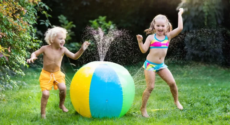 Image of boy and girl playing with water sprinkler an outdoor water toy