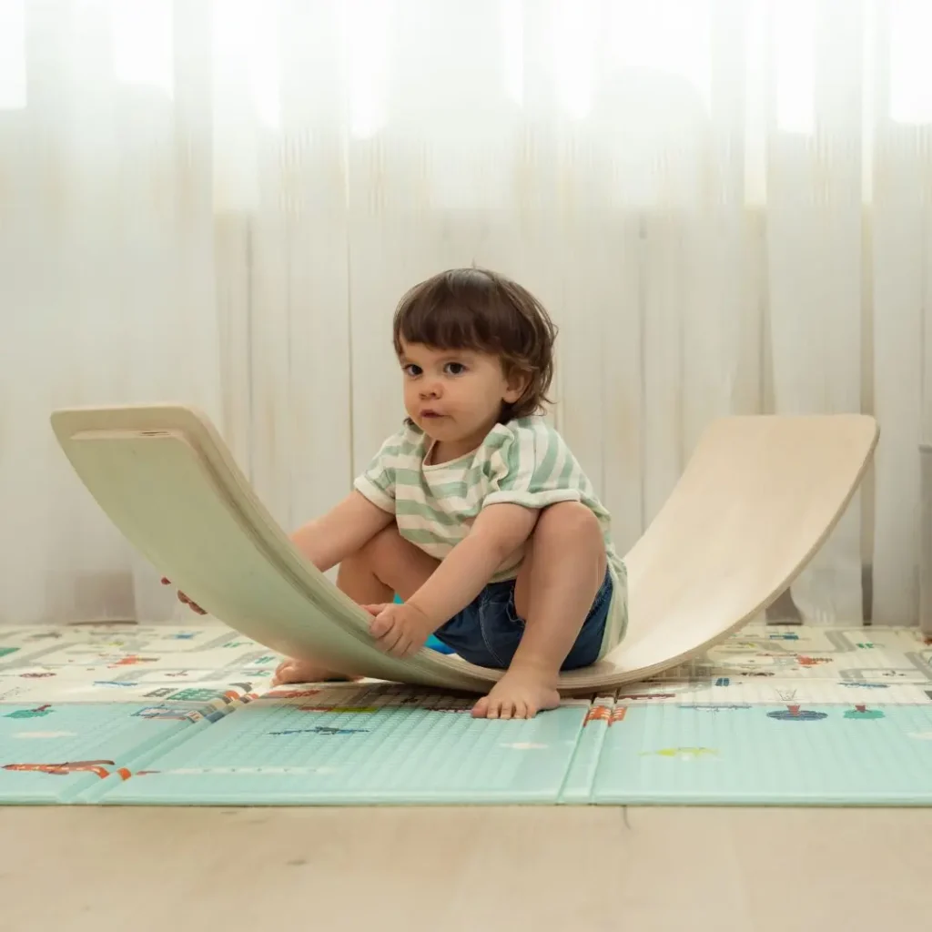 An image of a child playing with Wobble board 