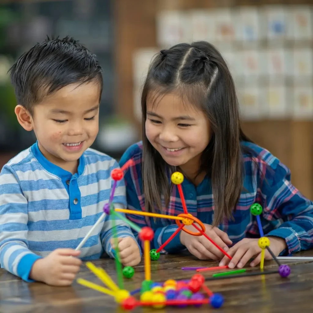 An image of 3 year olds playing with stacking toys