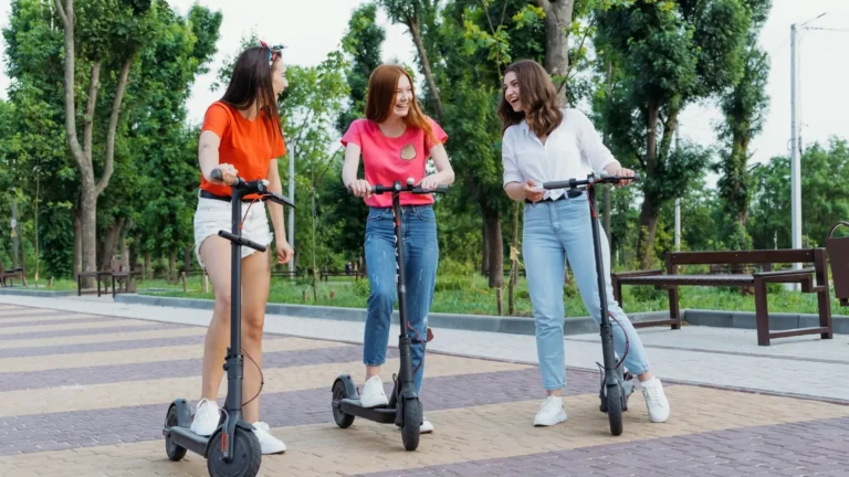 An image of 3 women riding electric scooters