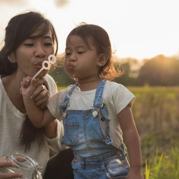 An image of a kid and mother playing with an outdoor toy