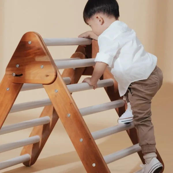 An image of a toddler climbing a pickler triangle