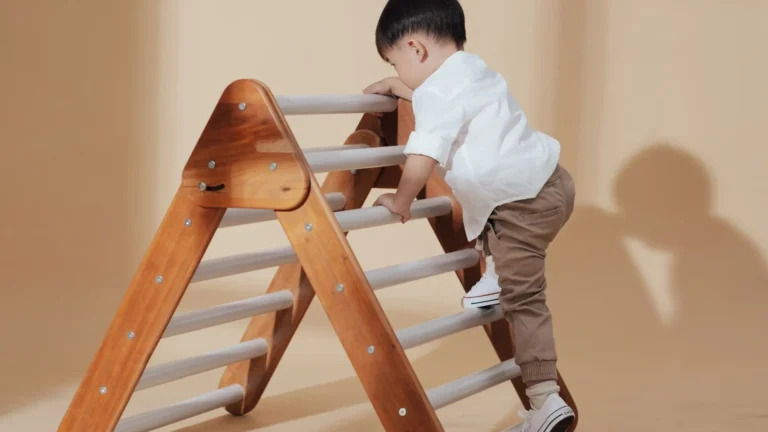 An image of a toddler climbing a pickler triangle