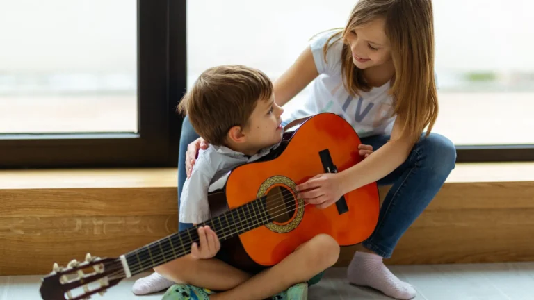 An image of kids playing with a guitar