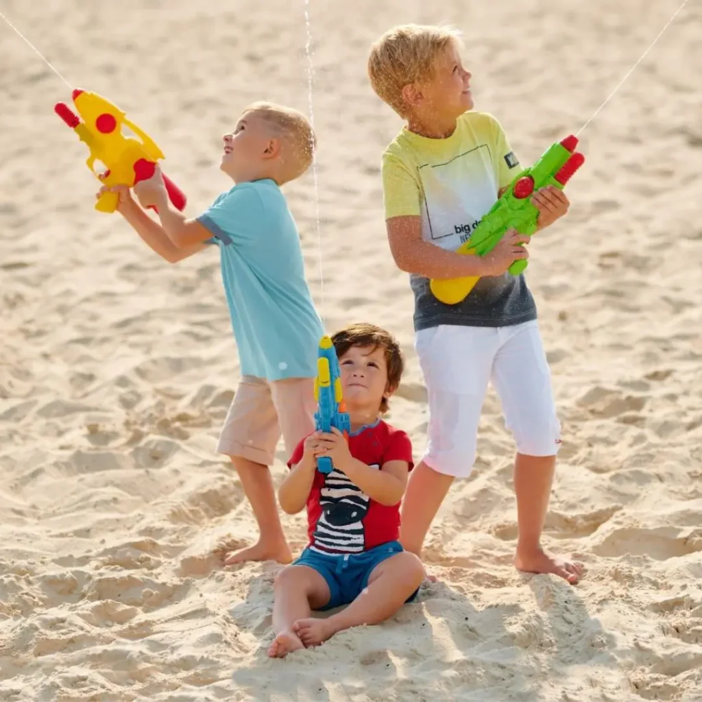 An image of Toddlers playing with water guns outdoor